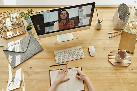 A student taking notes while video conferencing